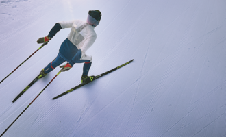 A skier glides down a perfectly groomed slope. The clear, snow-covered surroundings radiate calm and focus.
