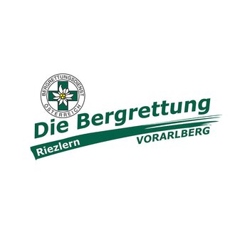 The image shows the logo of the Austrian Mountain Rescue Service. It is designed with the words "The Mountain Rescue Riezlern Vorarlberg" as well as an emblem featuring a flower. | © Bergrettung Vorarlberg