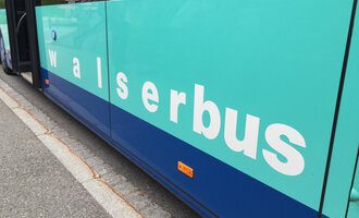 A bus with the inscription "walserbus". The colors are mint green and dark blue. | © Kleinwalsertal Tourismus