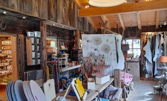 A cozy store with rustic wooden interiors. There are many products and decorations that invite browsing. | © iKuh Schöne Ideen | Daniela Neumann