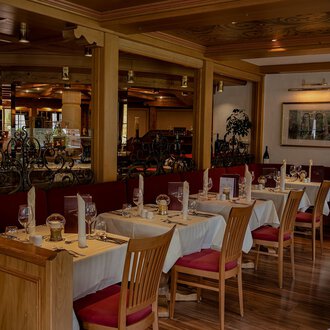 Ein gemütliches Restaurant mit Tischen und Stühlen aus Holz. Die Einrichtung ist warm und einladend, ideal für eine angenehme Mahlzeit. | © IFA Hotel Alpenhof Wildental