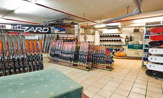 Ein Skiverleih mit vielen Skiern und Snowboards in einem gut organisierten Raum. Die Wände sind mit Ausrüstung und Zubehör zum Wintersport bedeckt. | © Aparthotel Kleinwalsertal Haller GmbH & Co KG