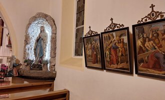 A church gallery with a statue of Mary and several historical paintings on the wall. The atmosphere is peaceful and reverent. | © Unterwestegg-Kapelle Maria Hilf | Tanja Ritsch
