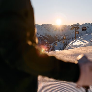 Alpine skier at sunset in Ifen, with mountain and chairlift in the background, during sunset. | © Kleinwalsertal Tourismus eGen • Photographer: Oliver Farys