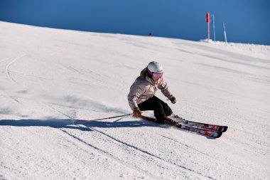 Frau beim Skifahren im Schnee, trägt Schutzhelm und Sportkleidung, skis zum Abfahren benutzt. | © Kleinwalsertal Tourismus eGen • Fotograf: Oliver Farys
